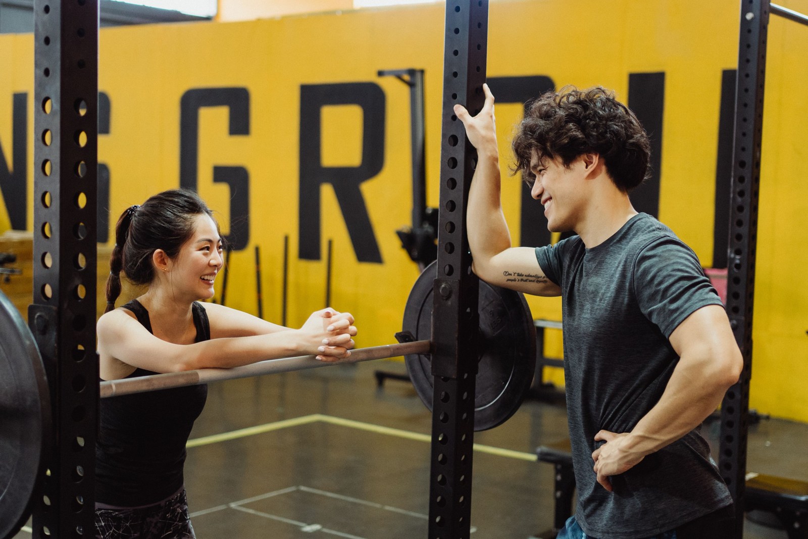 Deux sportifs échangent près d'un rack de musculation