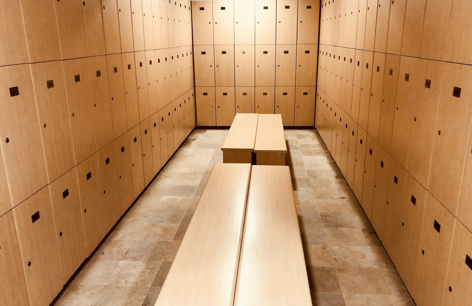 Vestiaires avec casiers en bois et bancs centraux